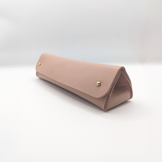 A pink triangular leather pen case with a sleek design, displayed on a white background.