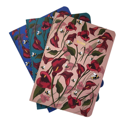 Set of three notebooks with floral design on a white background