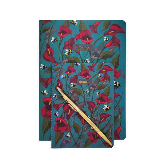 Floral soft cover notebook with a pen on a white background