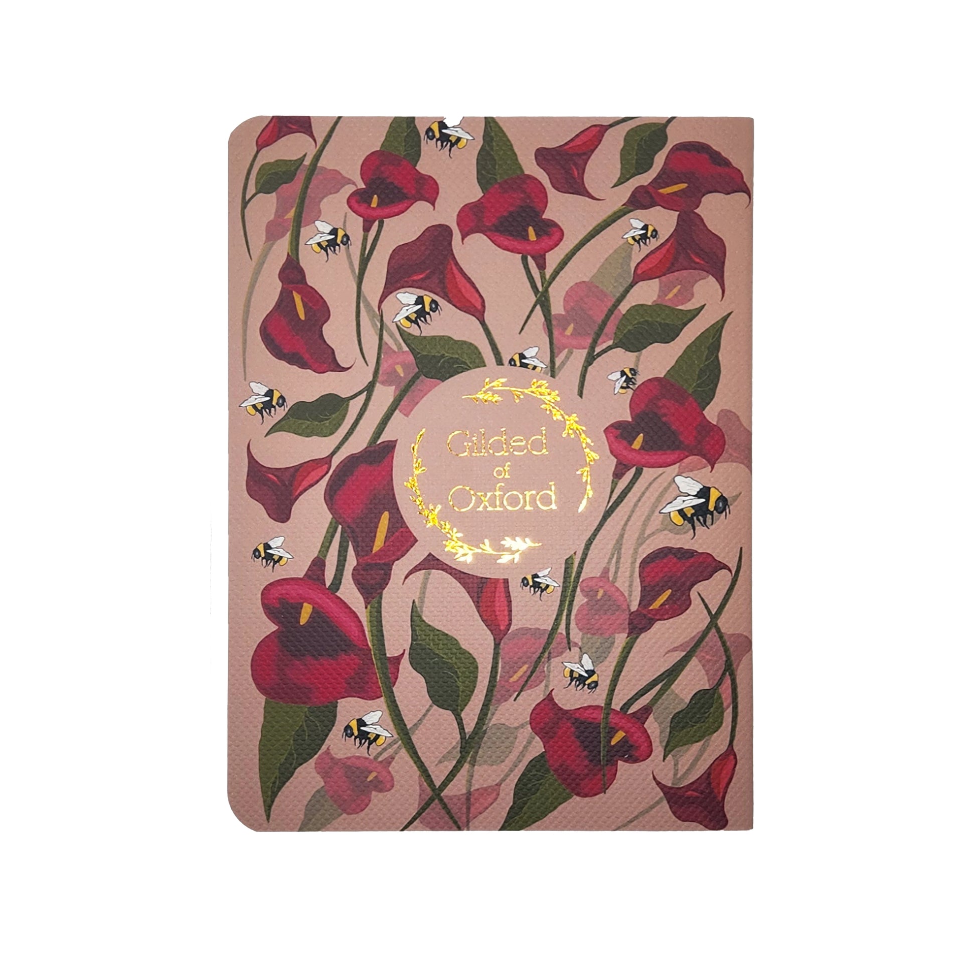 Notebook with floral design and 'Gilded of Oxford' text on a pink background